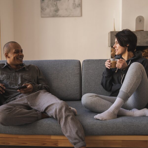 Happy young multiracial couple taking on sofa at home