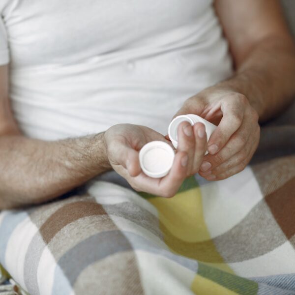 Man Sitting on Sofa and Taking Medication