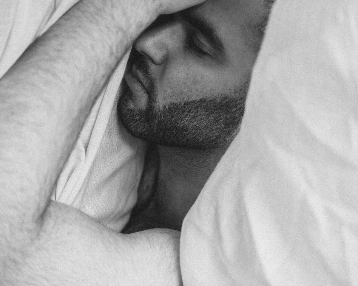 Serene man sleeping under blanket