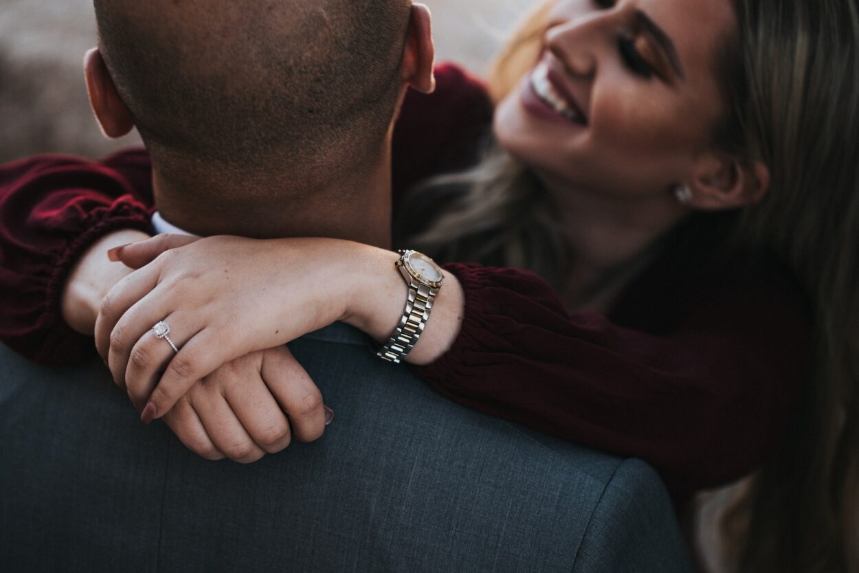 man in black suit jacket kissing woman in red shirt