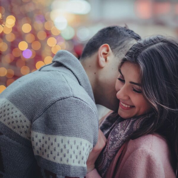 shallow photography of man hugging woman outdoors