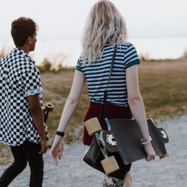 man and woman in white-and-black tops walking on pathway during daytime