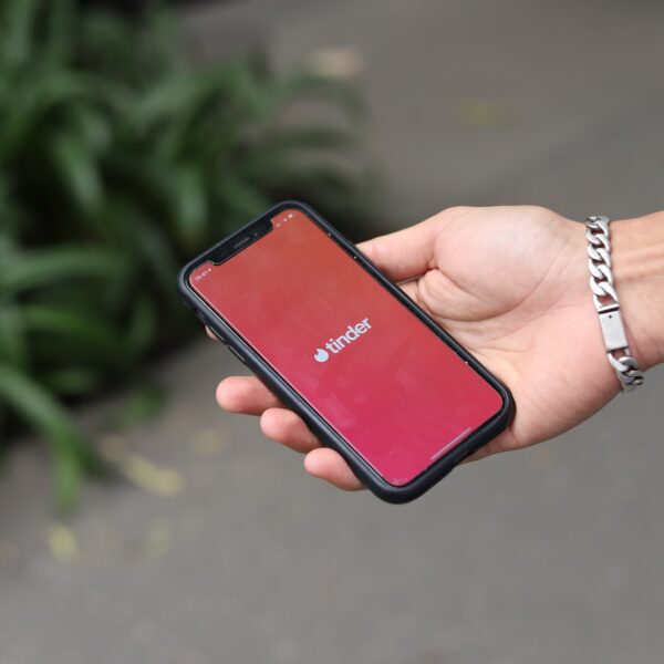 a person holding a red cell phone in their hand