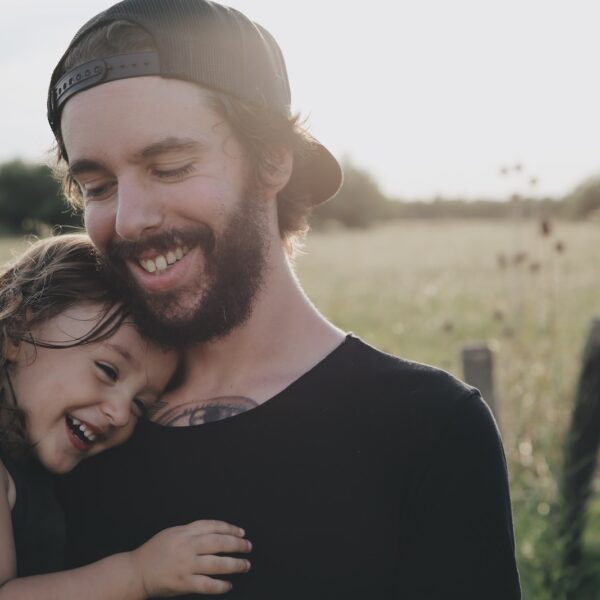 man carrying daughter in black sleeveless top