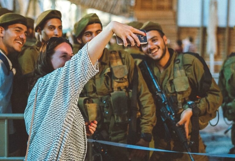 woman taking groupie picture with four militarys